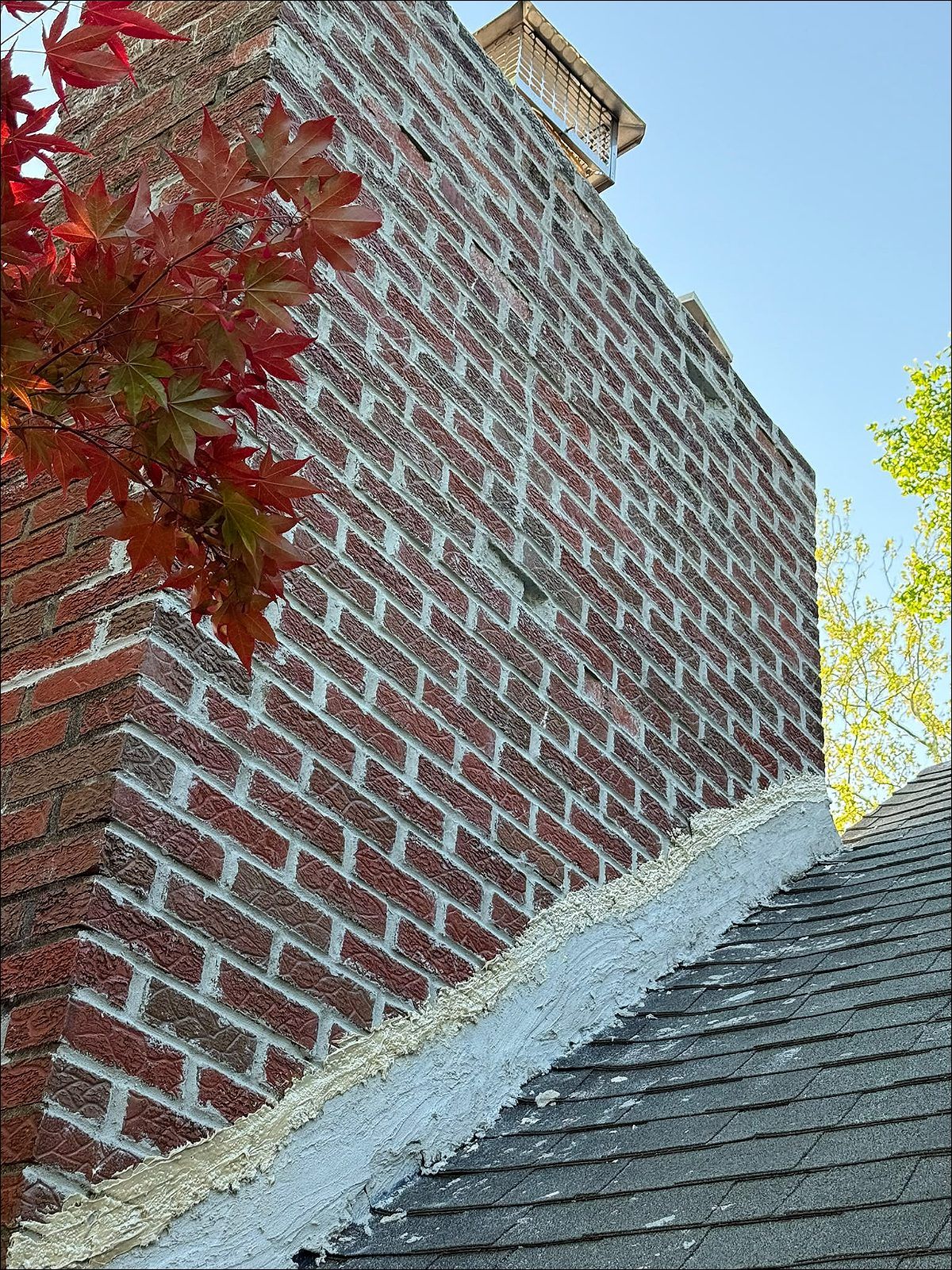 After: the same chimney repointed and sealed at the roofline